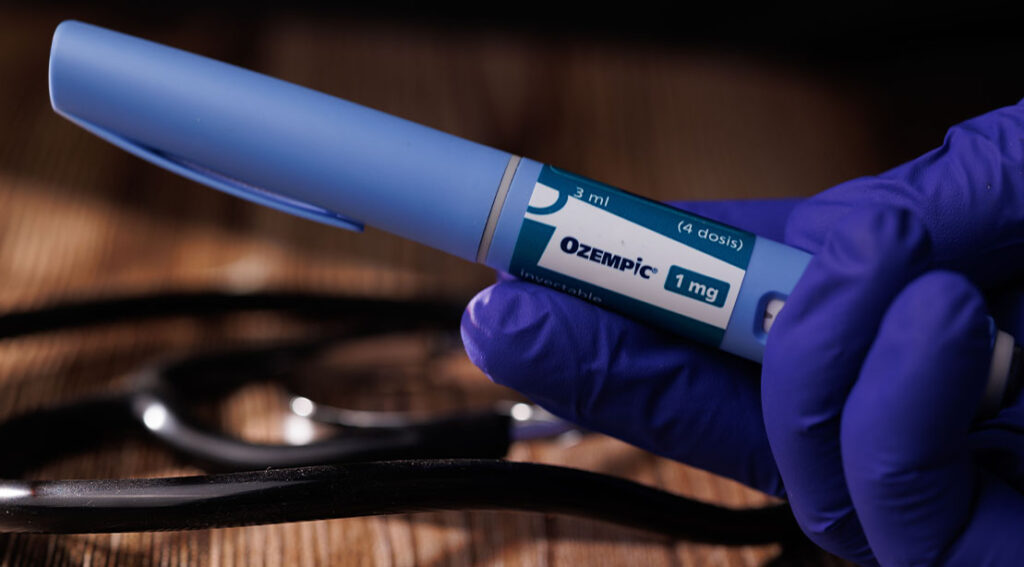 doctor wearing gloves holding a dose of ozempic.jpg