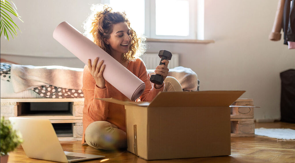 fit female unpacking fitness gear and wellness items from a box.jpg