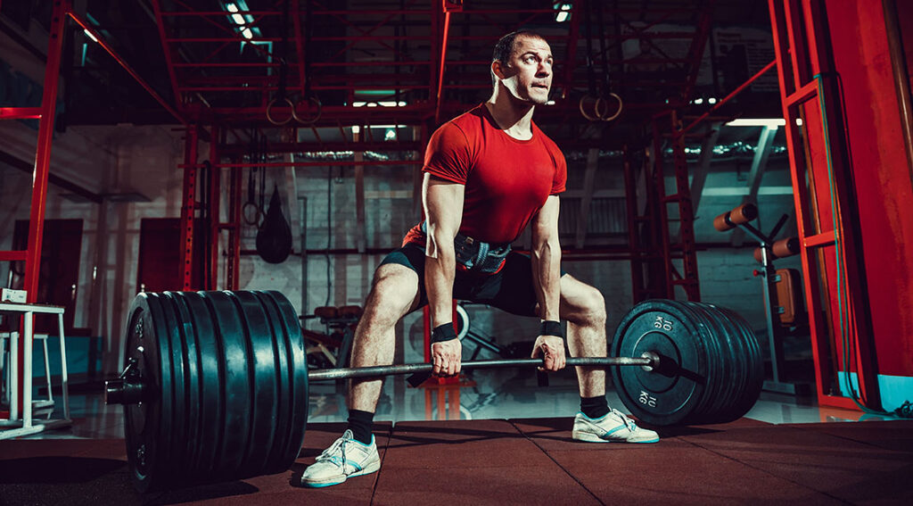 Sumo Deadlift vs Standard: Is It Dishonest or a Smarter Solution to Elevate Heavier? Strong Athletic Man Performing A Sumo Deadlift 1024x567