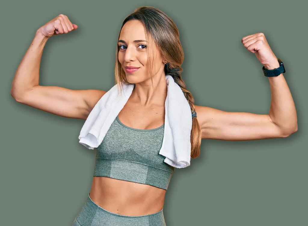 Towel Workouts To Construct Arm Energy After 55 happy woman flexing biceps with towel 2187773291.jpg