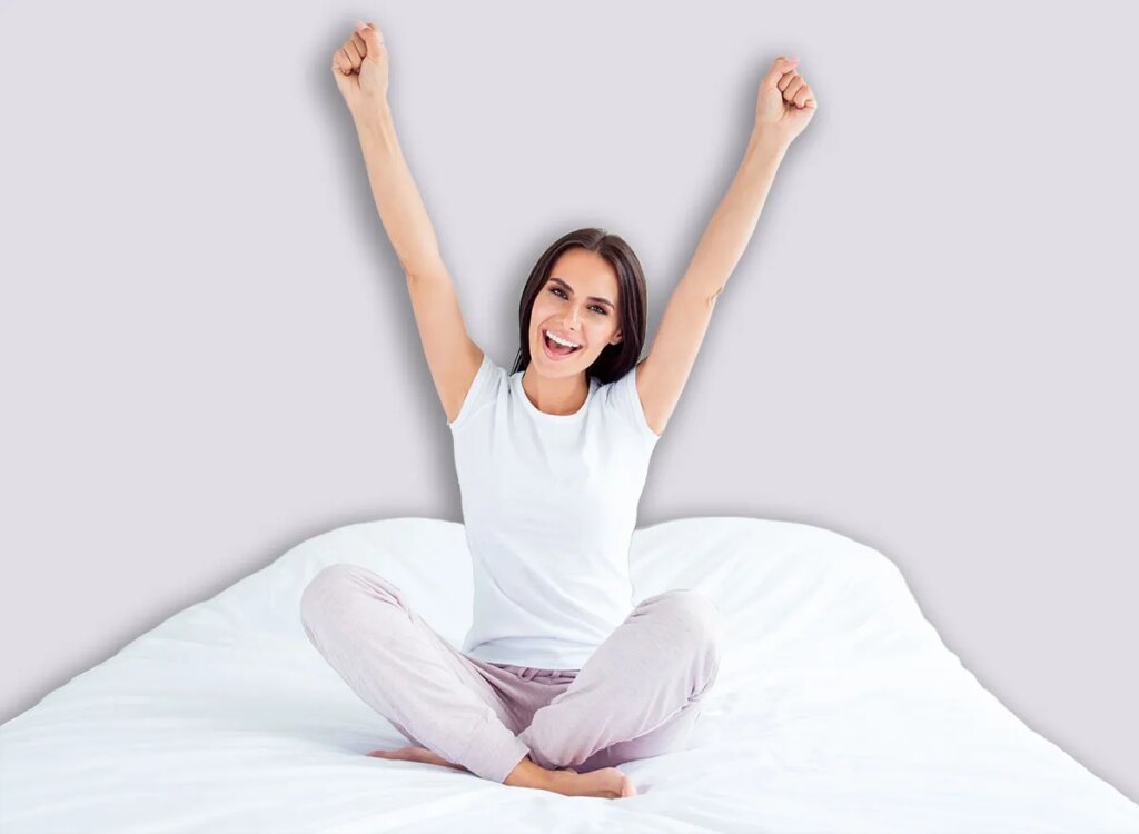 Inside Thigh Workouts in Mattress for Girls After 55 happy woman stretching on a bed 1162124674.jpg