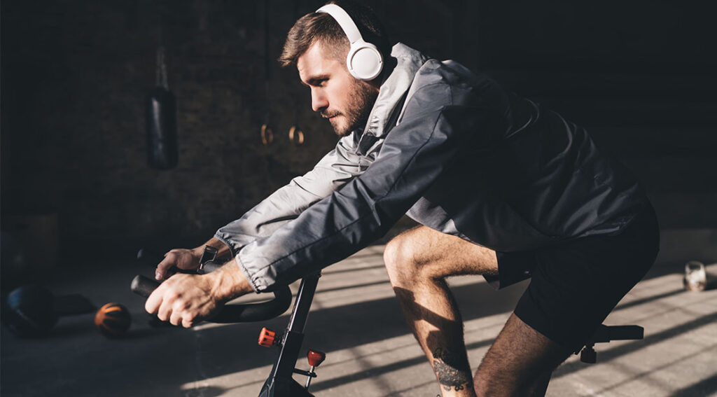 athletic young man listening to a workout playlist while performing a cardio workout on an exercise.jpeg