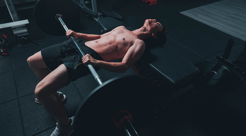 skinny man performing a hip thrust variation incorrectly.jpg