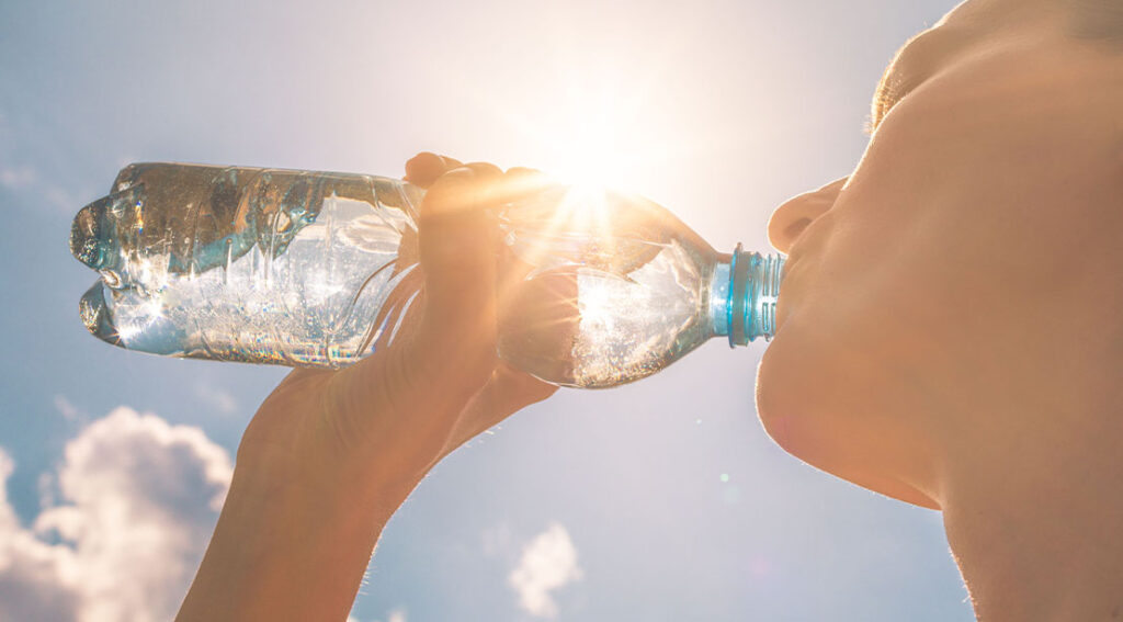 woman drinking a bottled water in the sun after a d 7 day water fast.jpg
