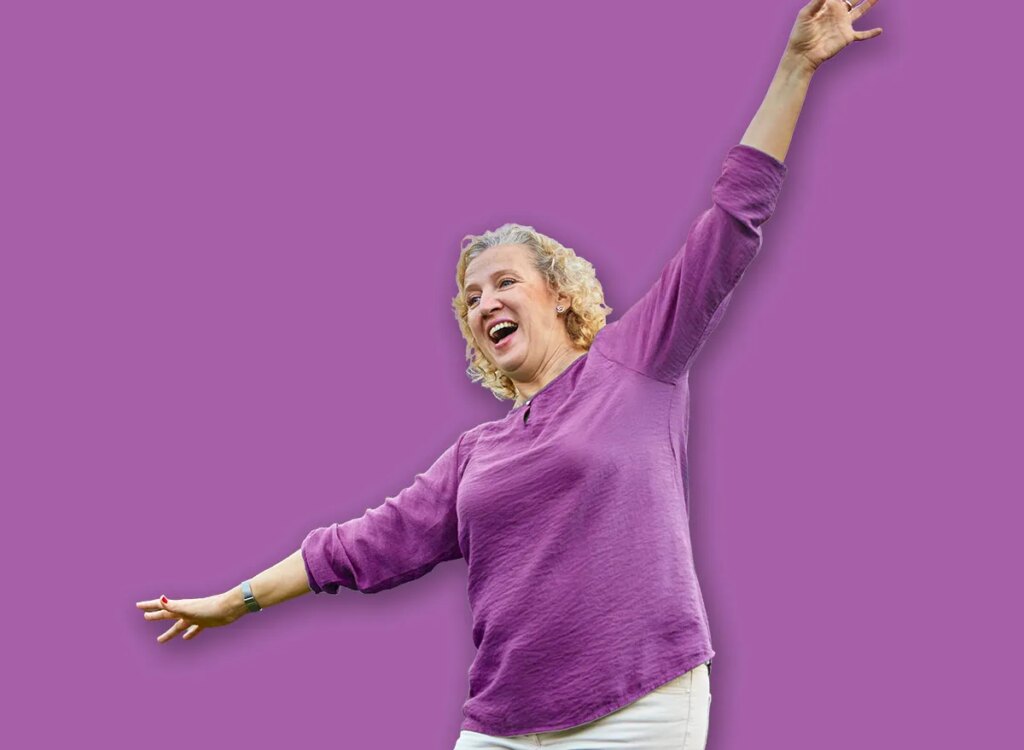 happy mature woman arms out balancing 2412930743.jpg