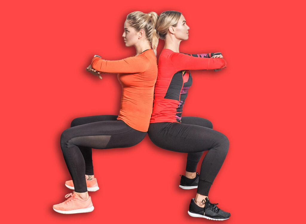 two women wall sit back to back exercise 759852967.jpg